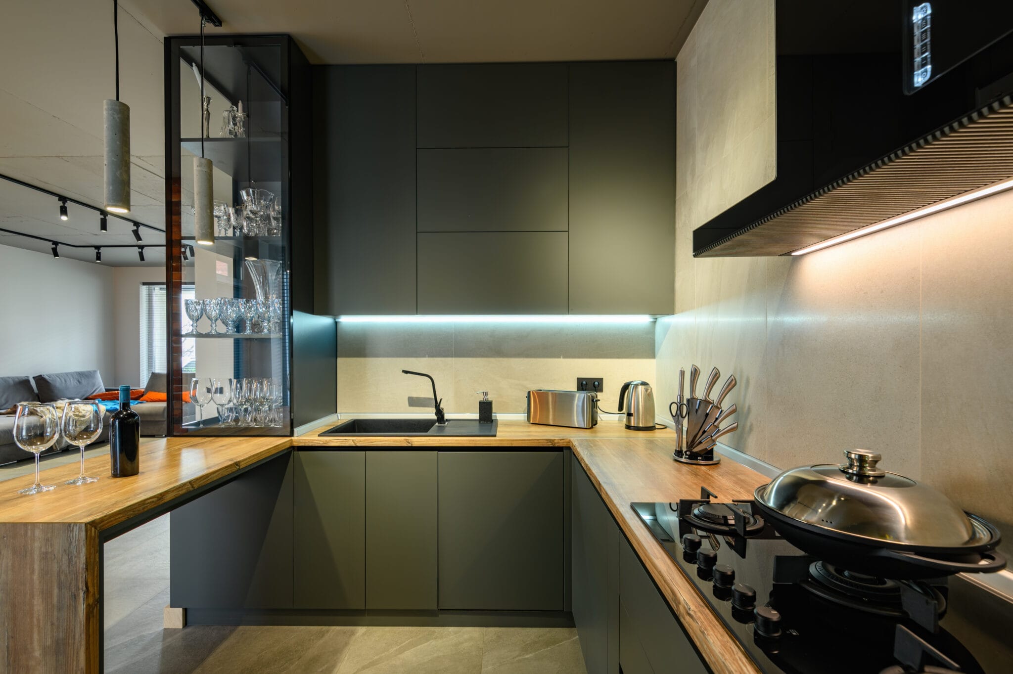 Modern large luxury dark gray kitchen closeup with wine bottle at kitchen counter, low key